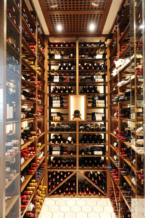 luxury wine room Marbella Lantana Florida, rich wood tones, ambient lighting, floor-to-ceiling wine racks, curated wine collection, Dragon Cellars