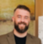 Midwest Games founder Ben Kvalo smiling against a yellow background