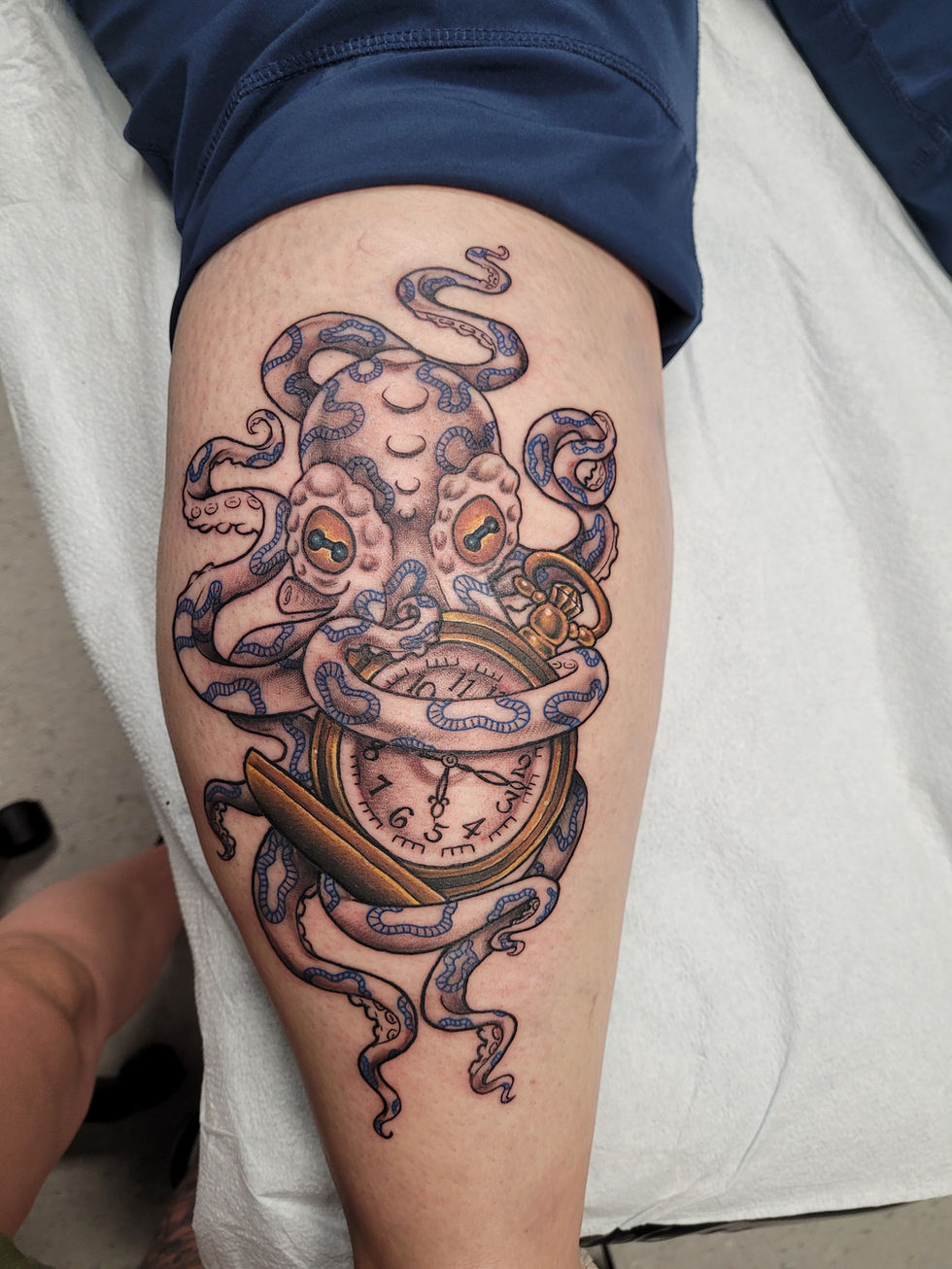 a tattoo of an octopus holding a pocket watch