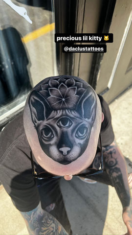 a man has a tattoo of a cat on his head