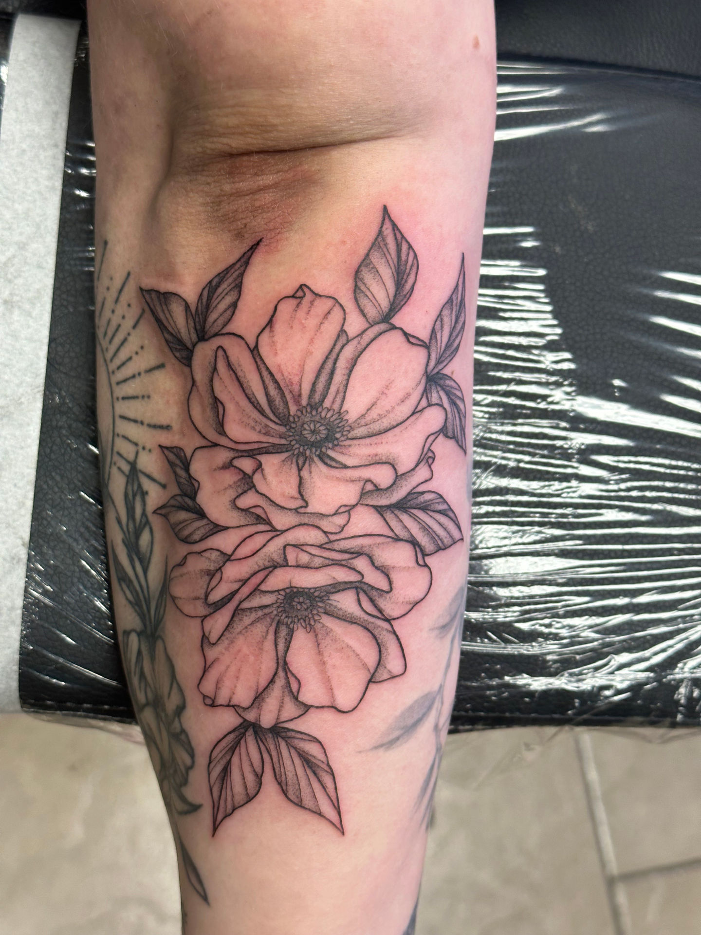 a woman has a tattoo of flowers on her leg