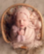 Newborn session in our Tampa studio with baby girl wrapped in pink
