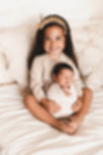 Sister snuggling with her newborn baby brother