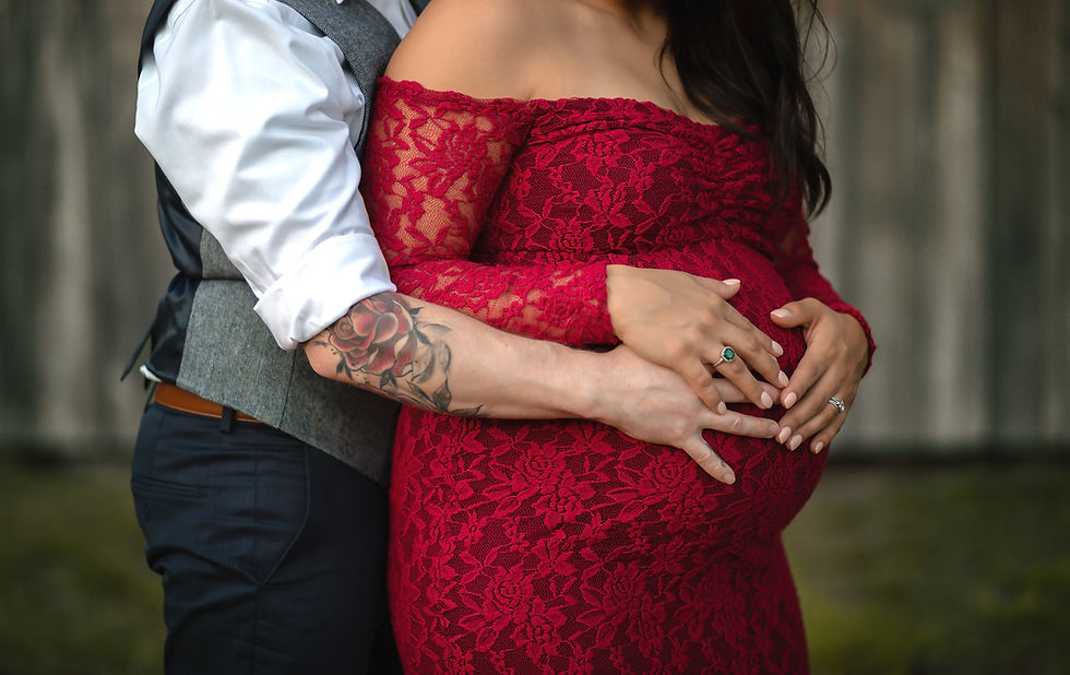 Mother and fathers hands holding a beautiful baby bump during pregnancy.