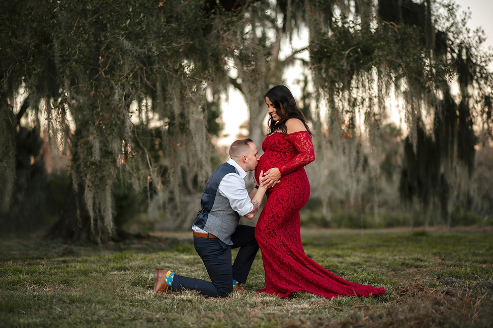Expecting mother and father kissing a baby bump during a maternity photo shoot