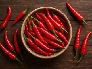 Cayenne pepper powder and fresh red chili showing natural health benefits