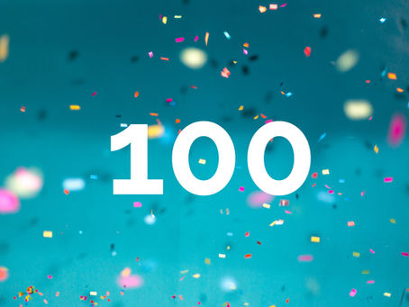Konfetti hinter einer Hundert Zahl auf blauem Hintergrund