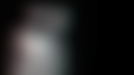A distorted image of a woman with a translucent self peeling away from her body against a black backdrop.