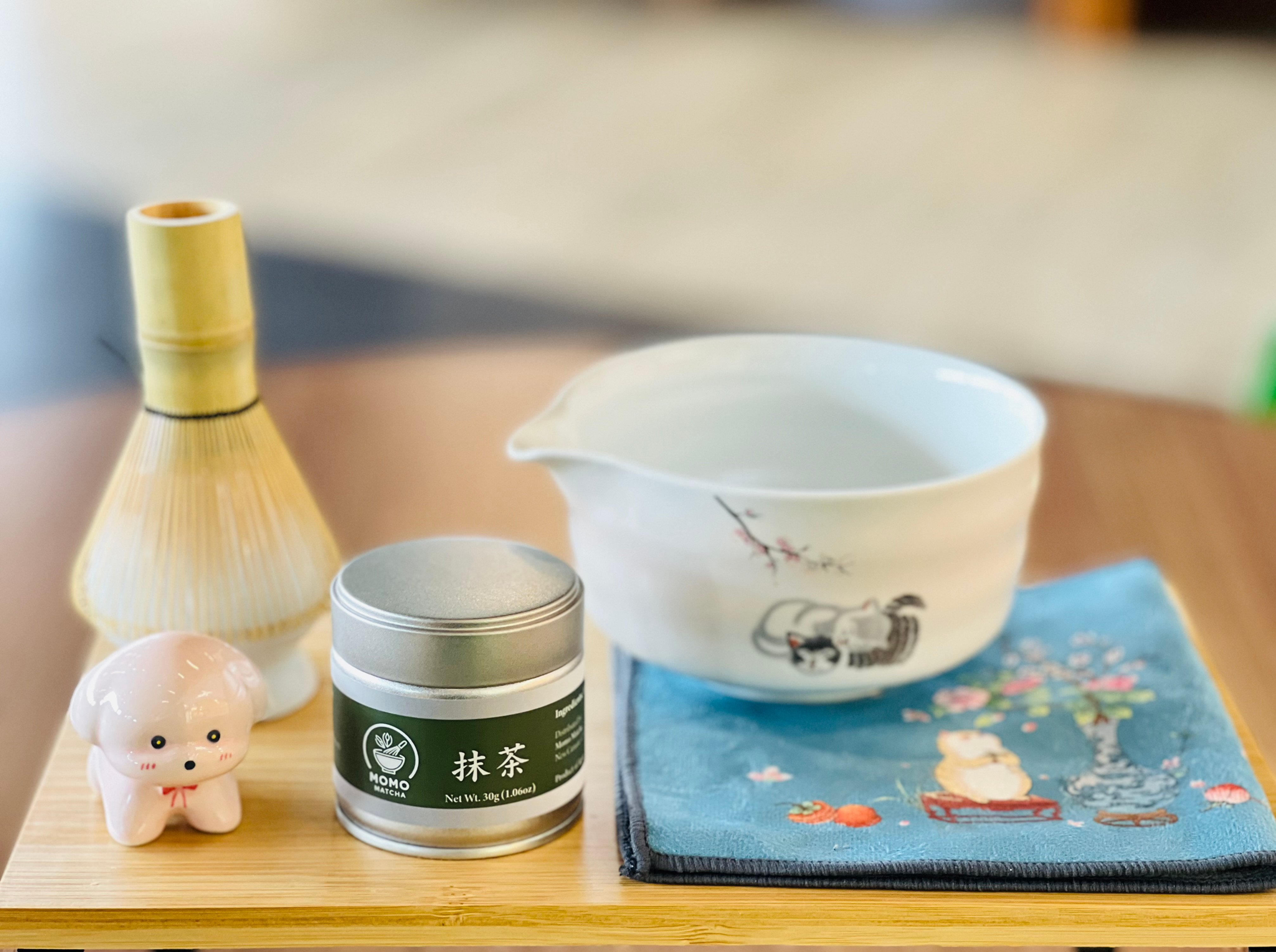 Matcha powder tin, chawan bowl, and whisk; Momo Matcha Ceremonial Grade Matcha Powder.