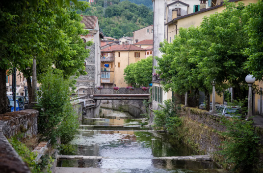 A warm sunlight filtering through a quiet cobblestone alleyway in a historic Italian village.