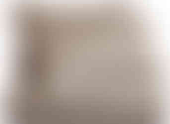 Folded velvet quilt in shimmery taupe with matching pillow covers on top