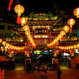 Chinese lanterns illuminate historic temple, Asian Supplies, celebrating a cultural festival at night.