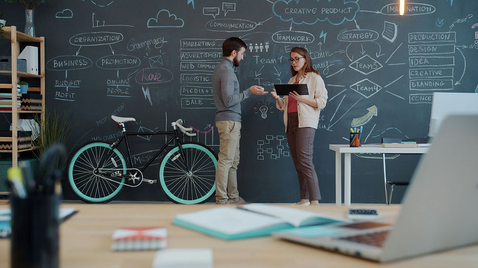 dos personas planeando un flujo de trabajo en una pizarra