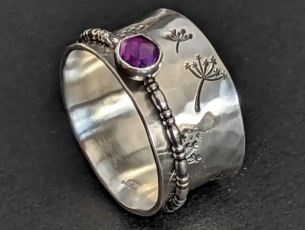 A very gorgeous wide ring stamped with Dandelions with an Amethyst Spinner.