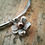 Thumbnail: A little silver and copper flower charm on a silver bangle. 