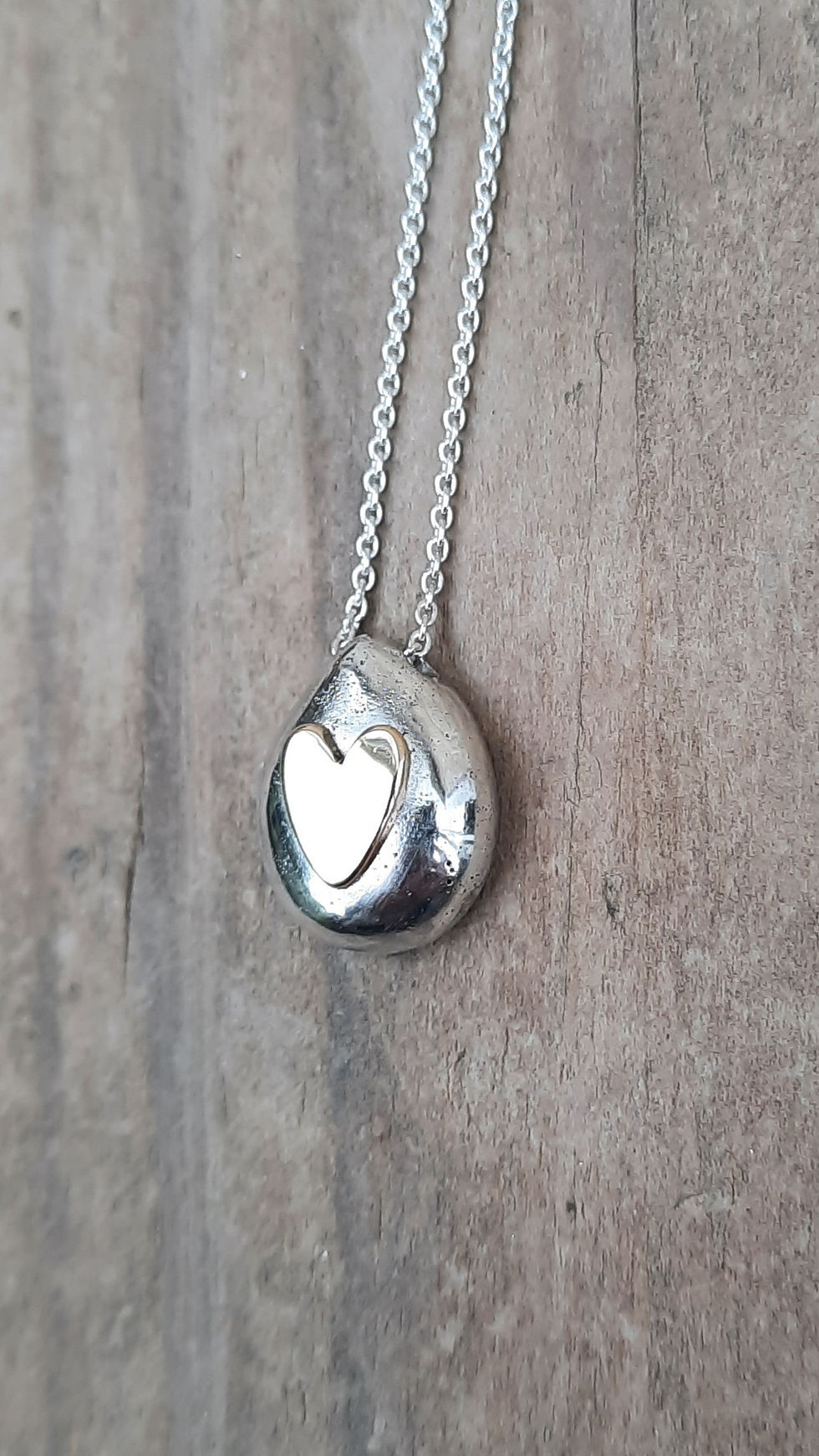 A one of a kind silver tear drop pebble with a 9ct gold heart.