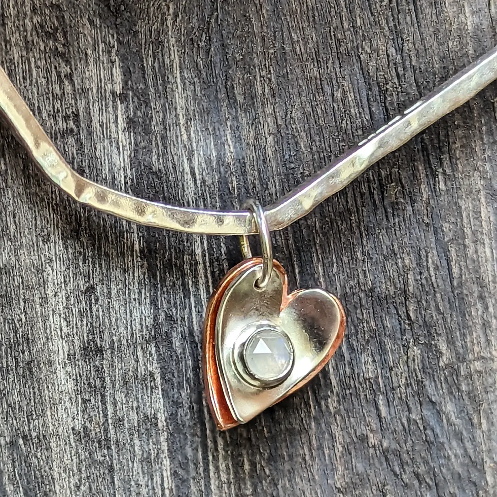 A square bangle with a copper heart, a silver heart and a Moonstone