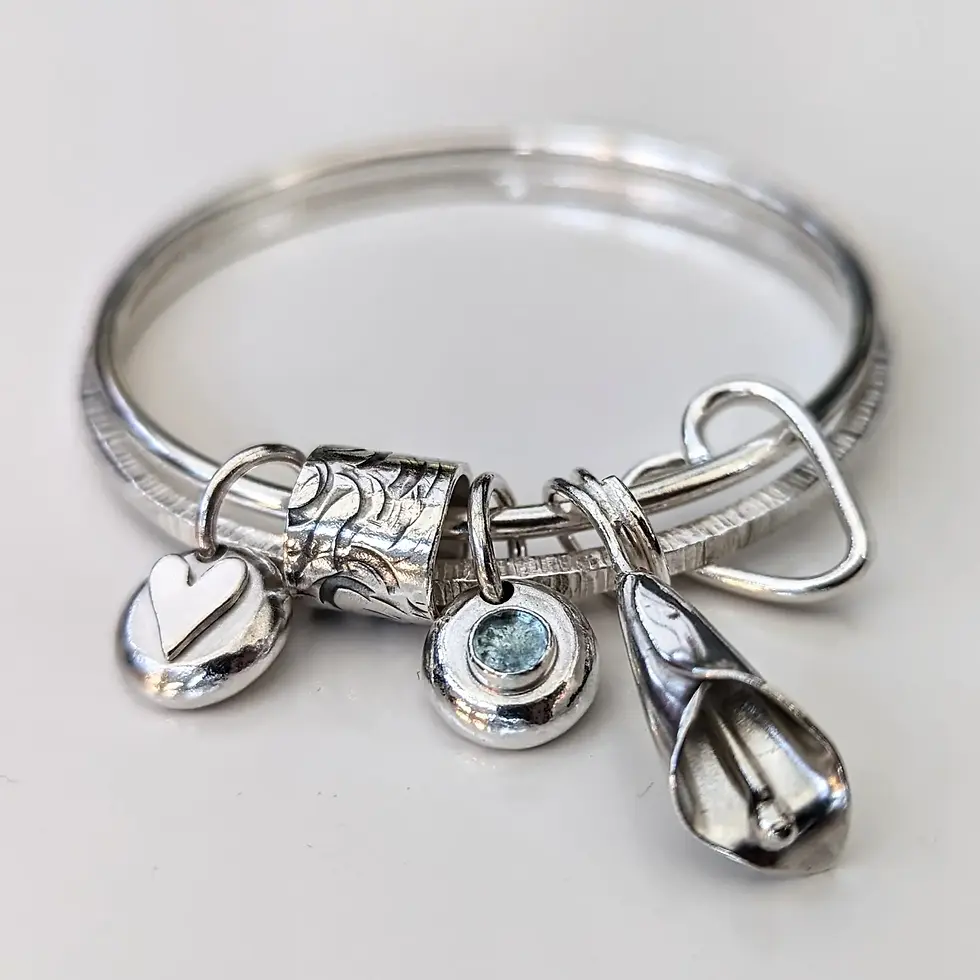 A Double Silver Bangle with Aquamarine,Calla Lily and Hearts.