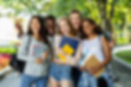 A group of young people smiling while holding books, showcasing a joyful moment of learning and friendship.