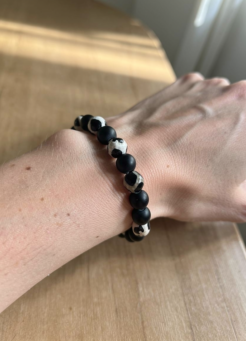 Handmade black obsidian and Tibetan agate bracelet on a wrist