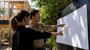 Architect and builder reviewing drawings on construction site