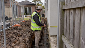 Surveyor inspecting a Melbourne boundary footing