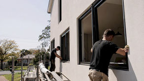 Builders installing new windows on suburban home