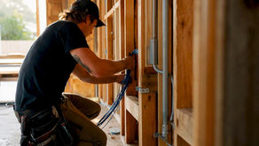Electrician pulling network cable in wall frame
