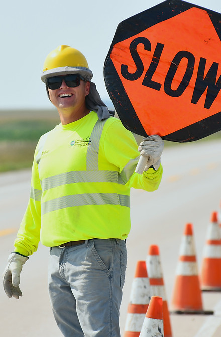 Iowa Lakes Electric Cooperative Employee holding slow sign