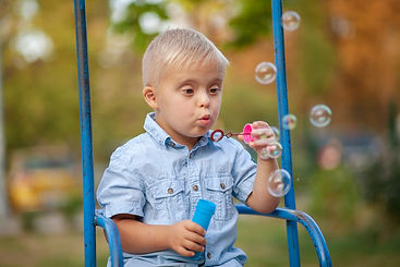 A young boy blows bubbles.