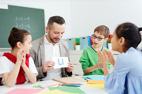 A teacher shows a flashcard to a group of students.