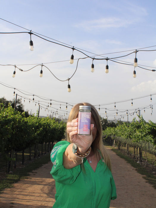 Woman holding phone, vineyard background
