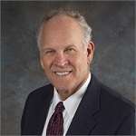 Smiling man in a suit for the Our Team page.