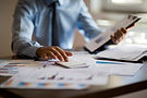 Accountant using a calculator with financial documents.