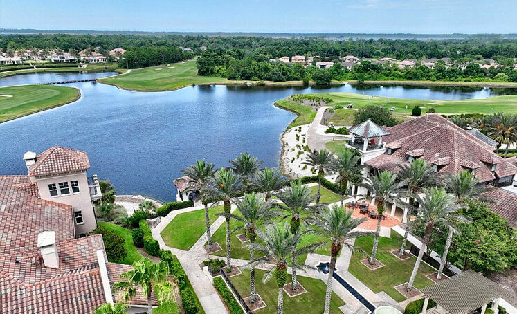 Aerial view of a Saint Augustine resort with palm trees and a lake.