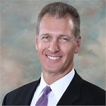 Smiling man in a suit and tie representing our team.