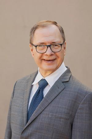 Smiling man in grey suit with glasses
