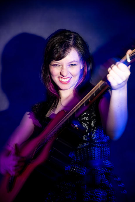 Cinematic studio portrait of singer songwriter Callum playfully laughing under colored lights shot in Baltimore.
