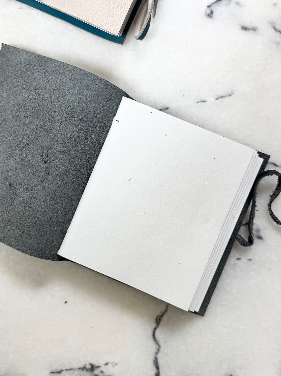 Thumbnail: Open gray leather journal, blank pages