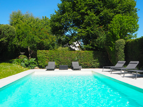 Piscine privée avec terrasse et transats disponible à la location entre particuliers.