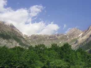Paysage des Pyrénées sous un ciel mêlant soleil et nuages, illustrant les prévisions météo de la semaine prochaine en Occitanie.