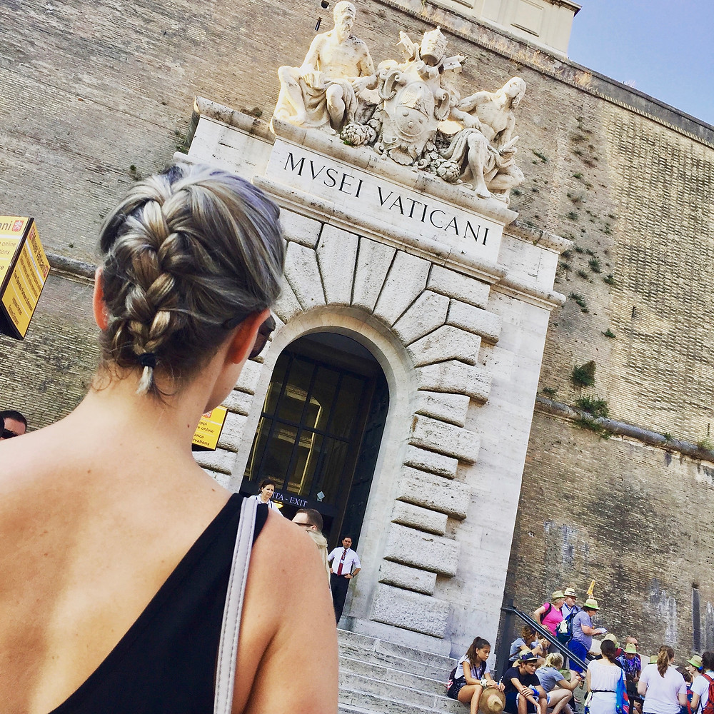 Woman looking at the entrance of the Vatican Museum from the outside