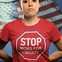 A woman wearing a red STOP Moms for Liberty shirt, with an American flag behind her