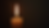Close-up view of a candle flame flickering in a dark room