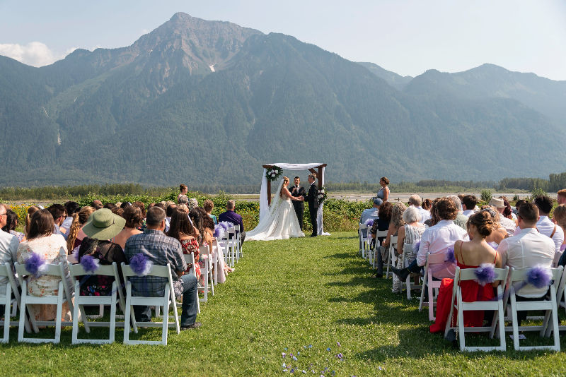 Outdoor mountain backdrop wedding ceremony at Fraser River Lodge.