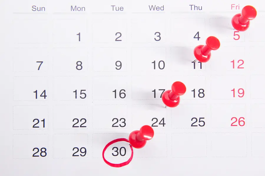 Wall calendar marked with pins, as a CCJ ages past four years on a credit file
