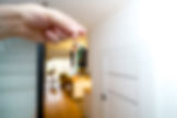Hand holding a set of keys in the doorway of a rented flat, illustrating a tenancy affected by rent arrears