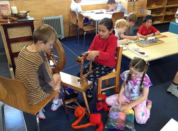 Handwork Builds Connections Children Using A Spinning Wheel To Spin Wool In Montessori Classroom Handwork Builds Connections Children Using A Spinning Wheel To Spin Wool In Montessori Classroom