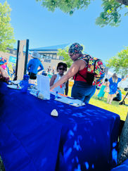 A parent and child at CPLAN's table during an outdoor resource event 