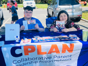 Two CPLAN members holding CPLAN brochures to share information with community members